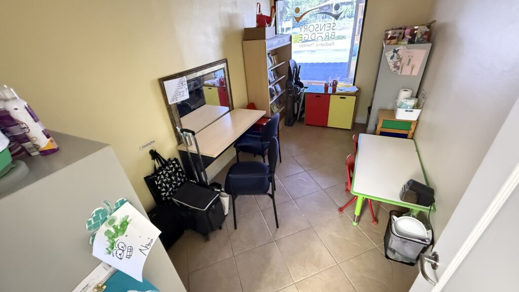 Feeding room with child-sized tables, chairs, a mirror and feeding supplies at Sensory Bridge Pediatric Therapy.