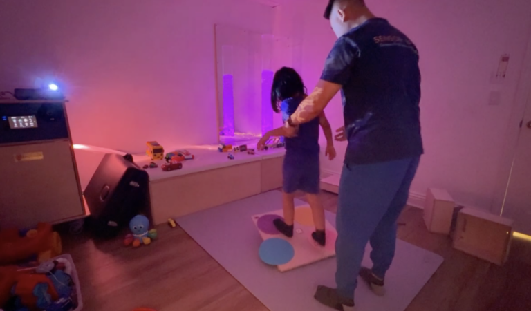 Adult and child exploring projected lights and bubble columns.
